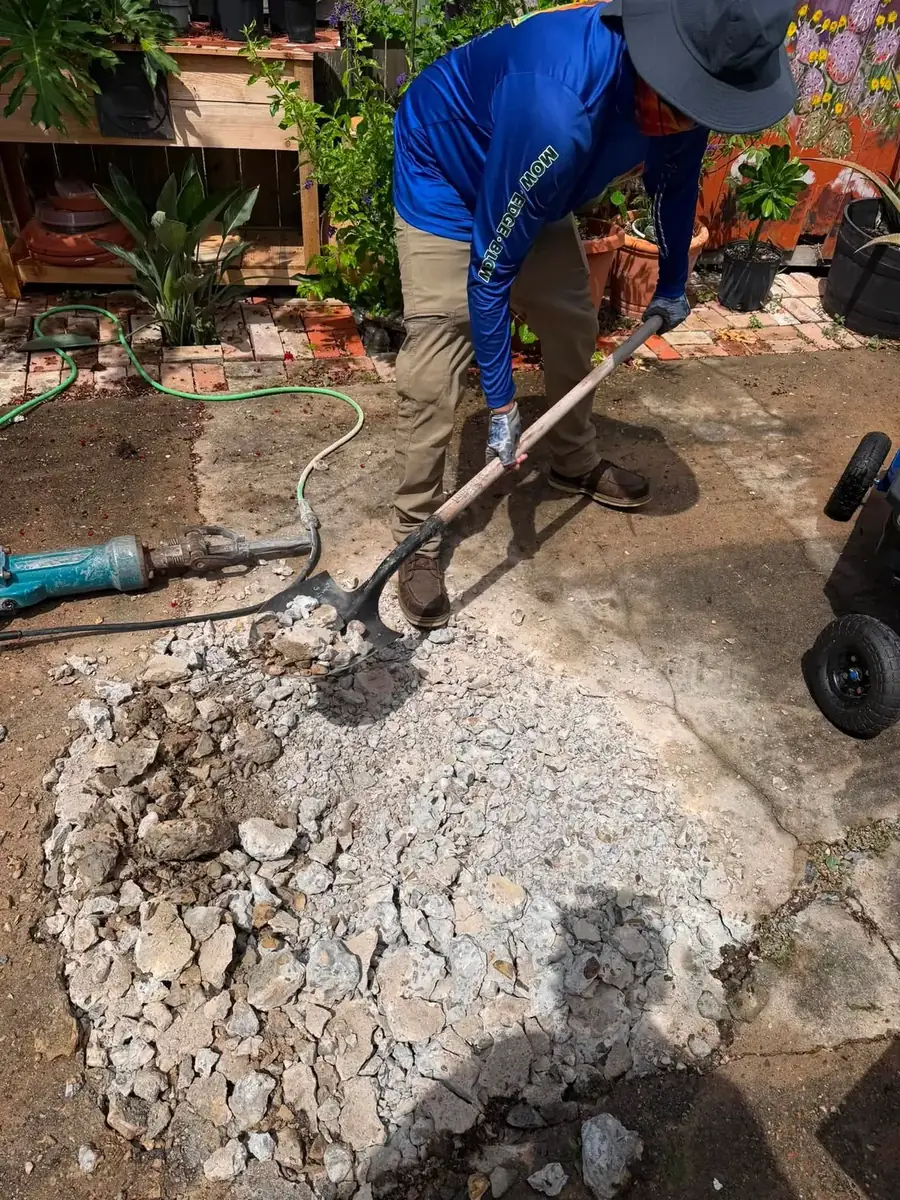 Breaking out concrete by hand to open a planting hole