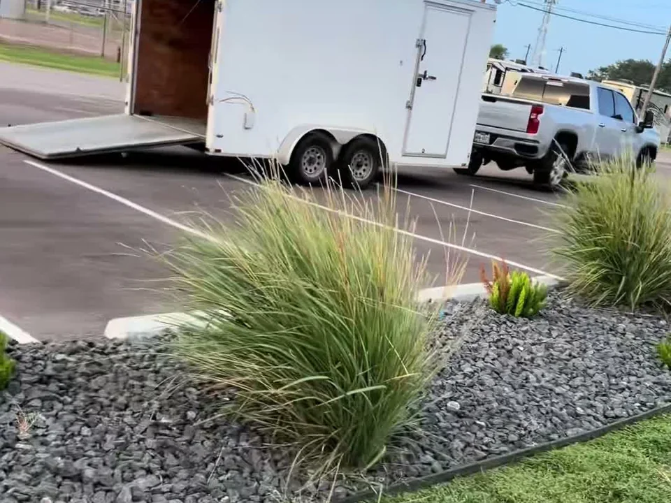 LRT's truck and trailer at a commercial property with fresh rock beds and ornamental grasses